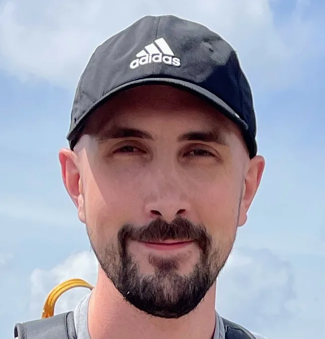 Colin White outdoors wearing a black cap